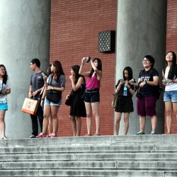 Asian tourists taking pictures of Taipei 101.
